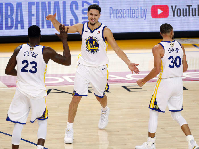 Golden State Warriors guard Klay Thompson (11) reacts with forward Draymond Green (23) and guard Stephen Curry (30) during overtime in game one of the 2018 NBA Finals at Oracle Arena.